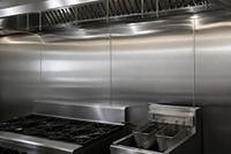 Stainless steel wall panels behind a cooking line